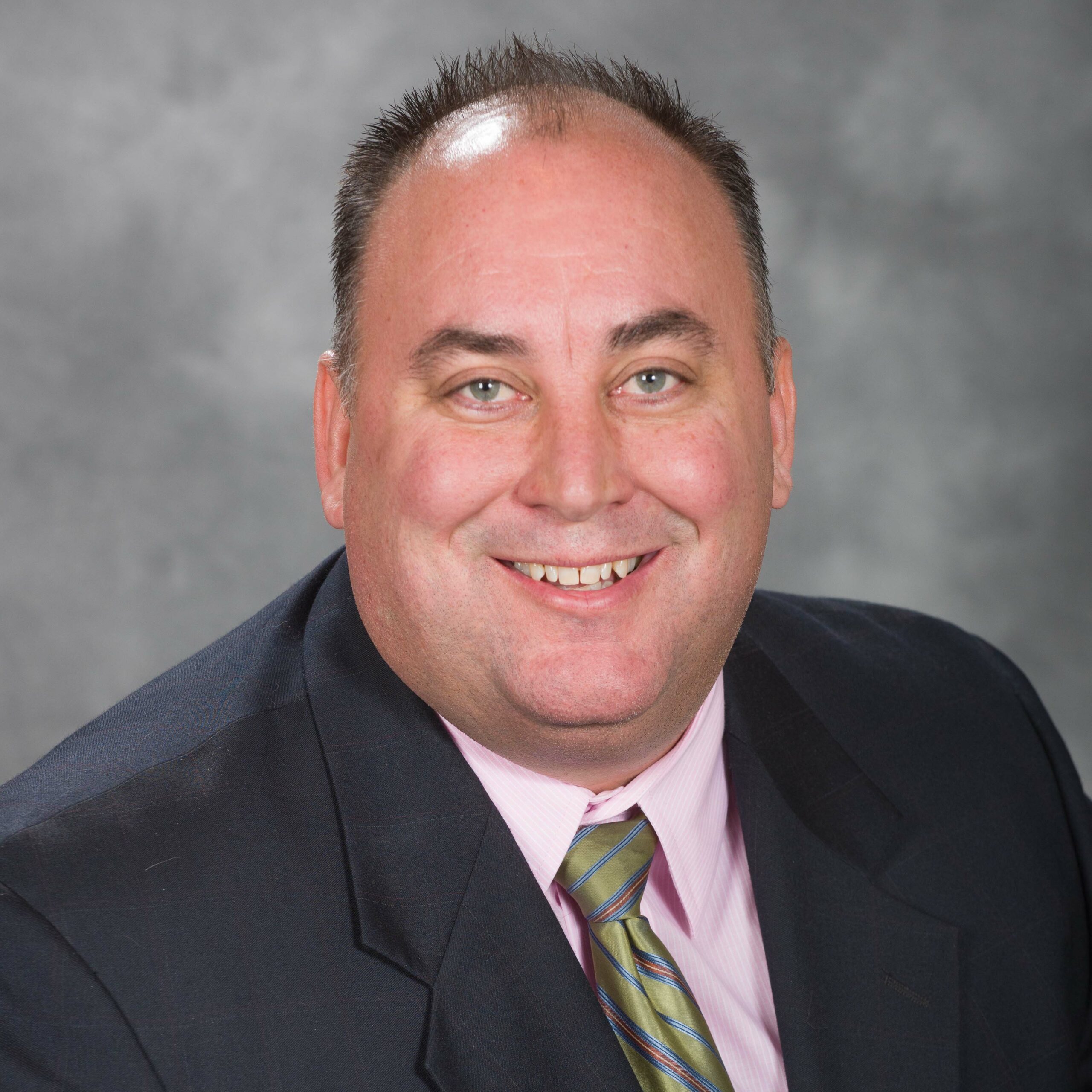 a man in a suit and tie smiling