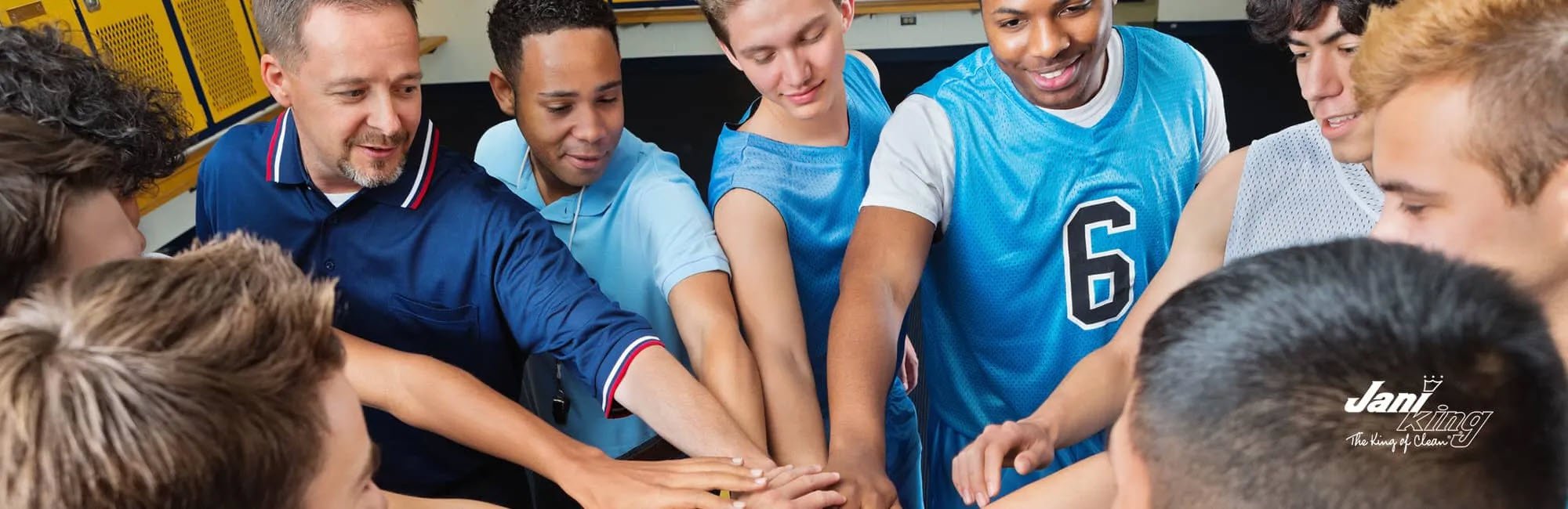 Coach with team getting hyped up in the locker room for the game.