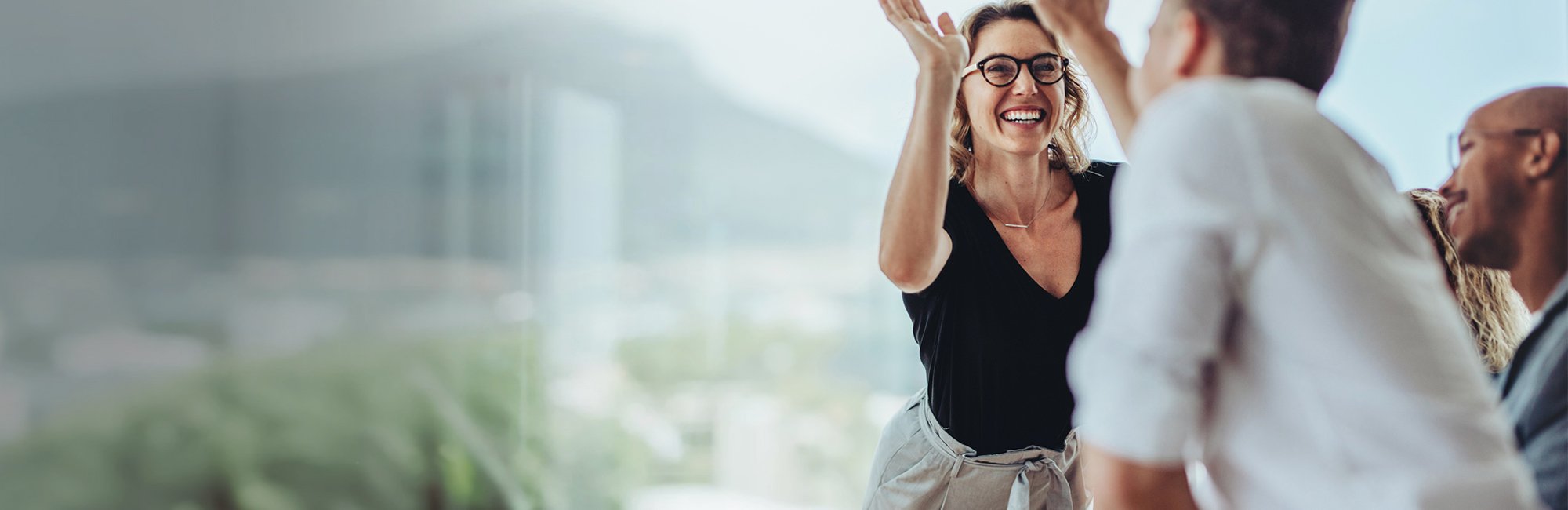 a woman in a black top and white pants is dancing with her hands up
