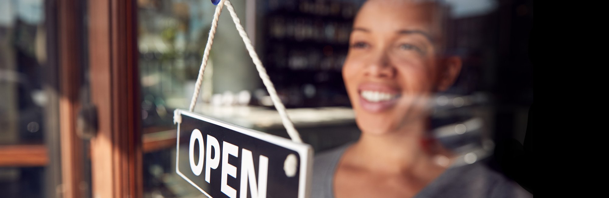 a woman is smiling and holding a sign