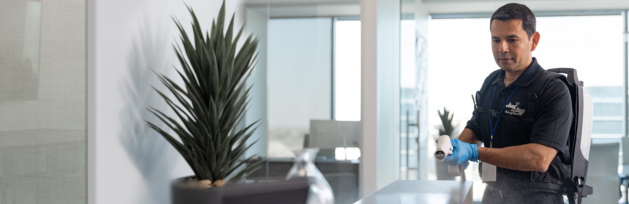 a man standing in a room with a plant