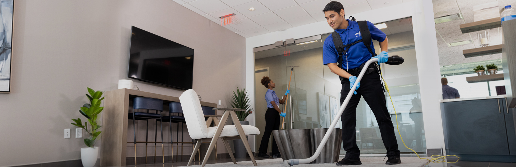 a man cleaning a room with a vacuum