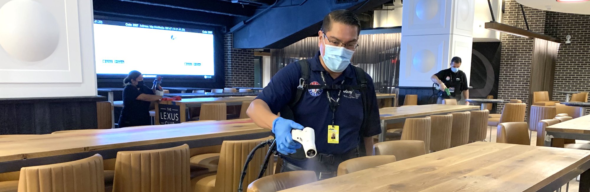 a man wearing a mask and holding sprayer at a restaurant