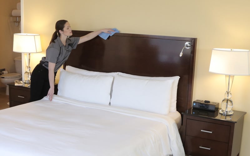 a woman cleaning a bed