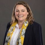 a woman in a yellow scarf and black jacket