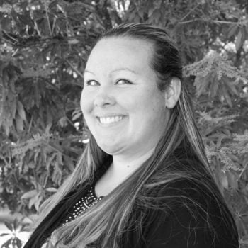 a woman standing under a tree