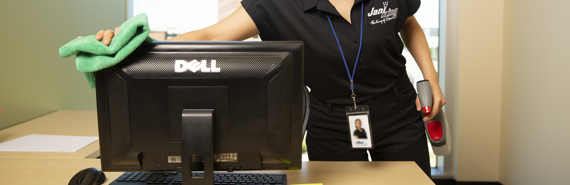 Jani-King employee cleaning a computer monitor